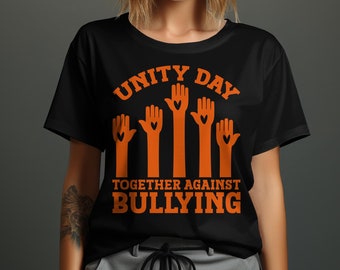 May include: Black t-shirt with orange text and graphics. The words "UNITY DAY" are arched across the top, with the phrase "TOGETHER AGAINST BULLYING" below. Orange hands with heart-shaped cutouts are featured in the center.
