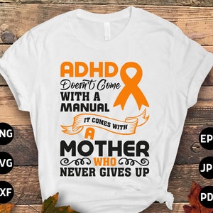 Pode incluir: Camiseta branca com uma fita laranja e o texto "ADHD Doesn't Come With A Manual It Comes With A Mother Who Never Gives Up".