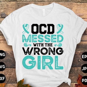 May include: White t-shirt with a teal blue ribbon design and the text "OCD messed with the wrong girl".