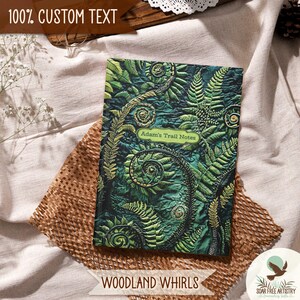 2 of 5 Forest aesthetic journal gifts for hikers, her or him. This woodland notebooks is called Woodland Whirls and is one of my most popular forest journals and is displayed on a beige outdoor picnic blanket. A rustic forest green nature journal is perfect for family camping memories, hiking adventures and forest lovers.