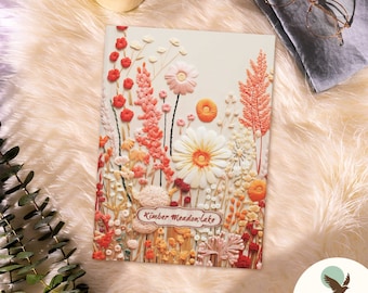 May include: A white notebook with a colorful embroidered floral design and the text "Kimber Meadow Lake" on the front cover.