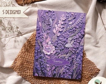 Może przedstawiać: Fioletowy notes z kwiatowym wzorem i tekstem "Fearless" 2 Tymoteusza 1:7. Okładka notesu ma wypukły, fakturowany wzór. Tekst "Violet Serenity" znajduje się na dole obrazu.
