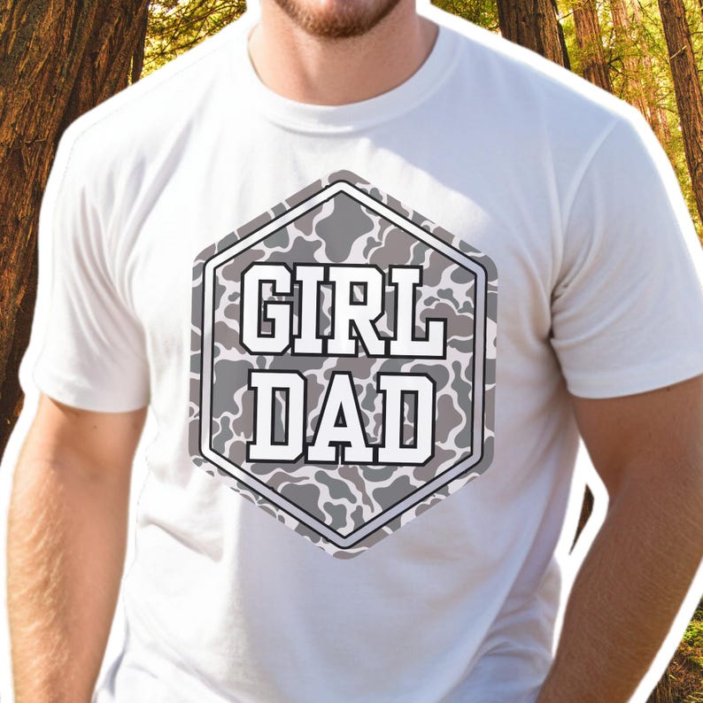 K&ouml;nnte beinhalten: Wei&szlig;es T-Shirt mit einem sechseckigen Tarnmuster, auf dem in wei&szlig;er Schrift "Girl Dad" steht.
