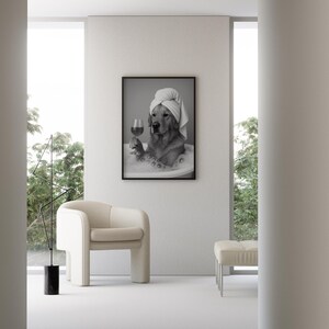 Pu&ograve; includere: Stampa incorniciata in bianco e nero di un Golden Retriever in una vasca da bagno, con un asciugamano in testa e un bicchiere di vino. La stampa &egrave; appesa a una parete bianca in una stanza moderna con una sedia e un pouf color crema.