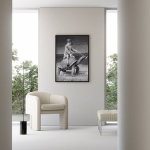 K&ouml;nnte beinhalten: Ein Schwarzwei&szlig;foto eines Kindes, das auf einer gro&szlig;en Schildkr&ouml;te reitet. Das Foto ist gerahmt und h&auml;ngt an einer wei&szlig;en Wand in einem modernen Wohnzimmer.