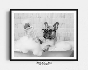 Puede incluir: Una fotografía en blanco y negro de un bulldog francés con gafas leyendo un periódico mientras está sentado en una bañera llena de burbujas.