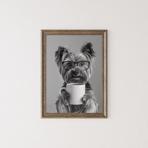 May include: Black and white photograph of a Yorkshire Terrier wearing glasses and holding a white coffee mug.