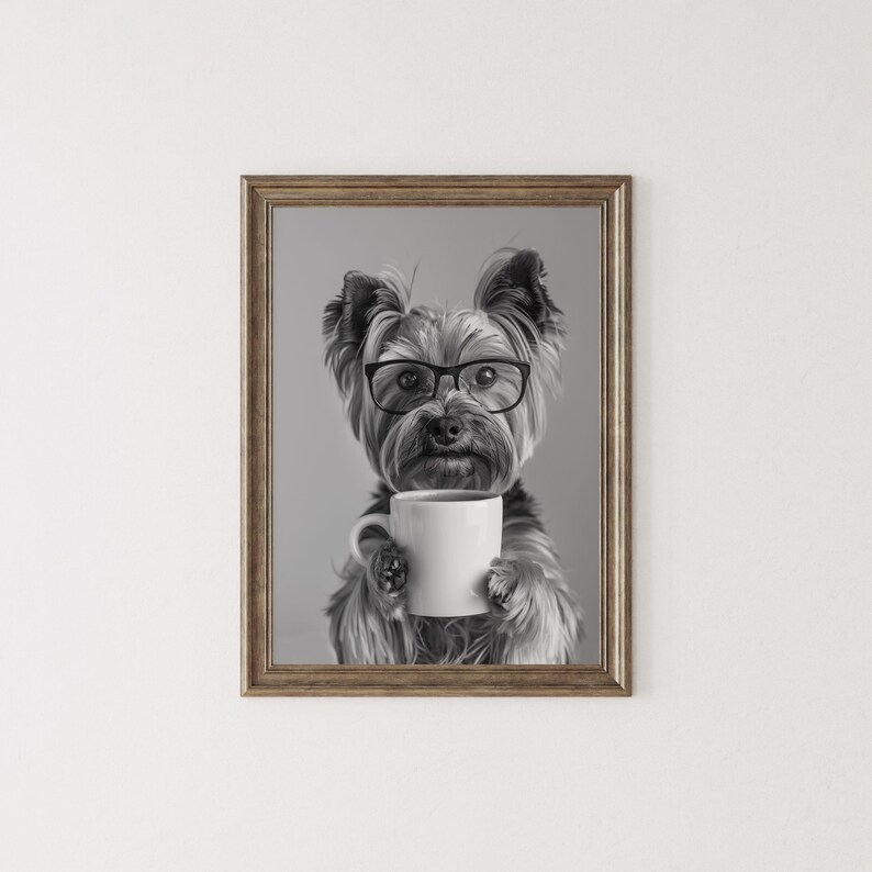 May include: Black and white photograph of a Yorkshire Terrier wearing glasses and holding a white coffee mug.