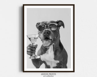 May include: A black and white photo of a dog wearing sunglasses and holding a martini glass. The dog is smiling and looking at the camera.