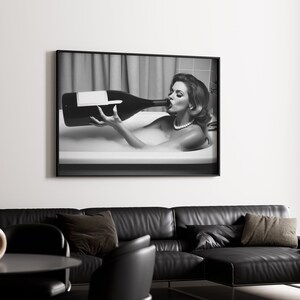Peut inclure: Photographie en noir et blanc d'une femme dans une baignoire buvant une grande bouteille de champagne.
