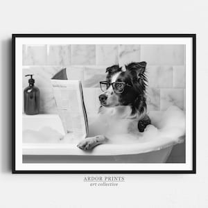 May include: A black and white photo of a dog wearing glasses and reading a newspaper while sitting in a bathtub full of bubbles.