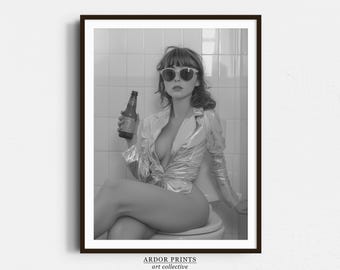 Puede incluir: Una fotografía en blanco y negro de una persona con gafas de sol y una camisa de color claro, sosteniendo una botella de cerveza en un baño.