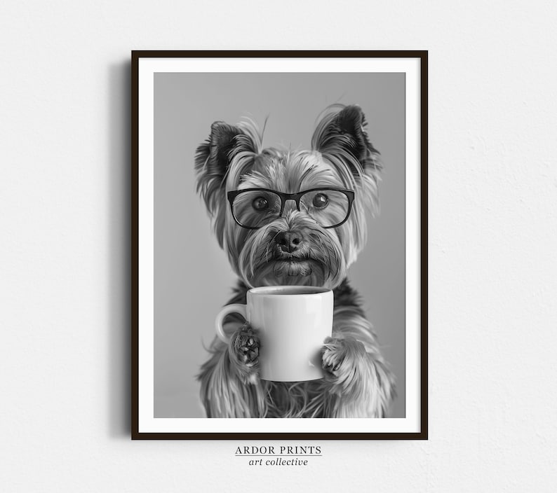May include: A black and white photograph of a Yorkshire Terrier wearing glasses and holding a white coffee mug. The dog is looking directly at the camera.