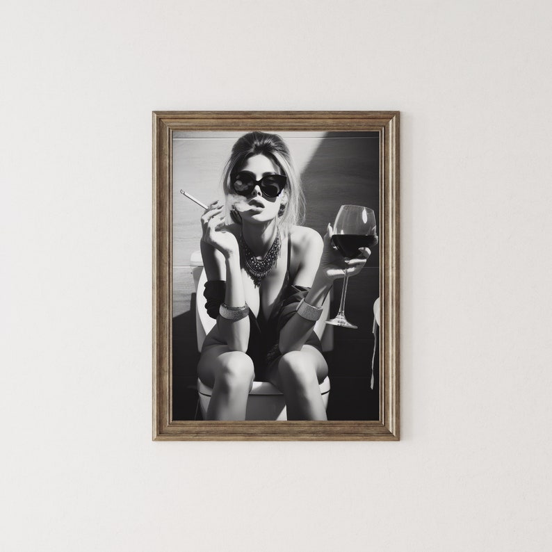 K&ouml;nnte beinhalten: Schwarzwei&szlig;foto einer Frau mit Sonnenbrille und schwarzem Oberteil, die auf einer Toilette sitzt, ein Glas Rotwein h&auml;lt und eine Zigarette raucht.