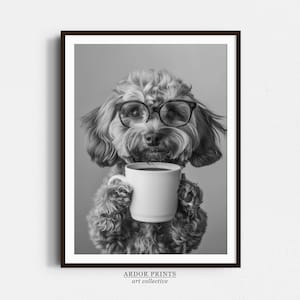 Peut inclure: Une photo en noir et blanc d'un chien portant des lunettes et tenant une tasse de café. Le chien regarde la caméra. La photo est encadrée dans un cadre noir avec le texte "ARDOR PRINTS art collective" en bas.