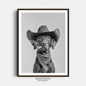 Könnte beinhalten: Ein Schwarzweißfoto eines Hundes, der einen Cowboyhut trägt und einen Zigarren in seinem Maul hält. Der Hund schaut direkt in die Kamera.