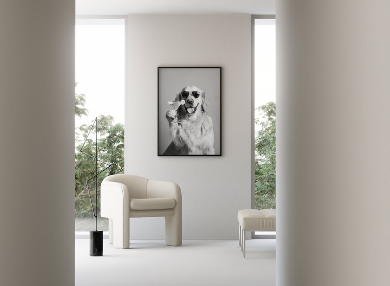Op de afbeelding: Een zwart-witfoto van een golden retriever die een zonnebril draagt en een martini-glas vasthoudt. De foto is ingelijst en hangt aan een witte muur in een moderne woonkamer.