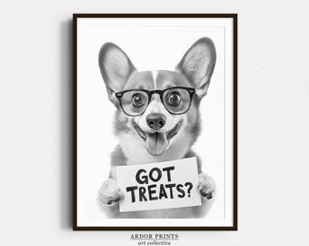 May include: Black and white framed print featuring a smiling corgi wearing glasses and holding a sign that reads "GOT TREATS?". The print has a white background and a black frame. The bottom of the print has the text "ARDOR PRINTS art collective".