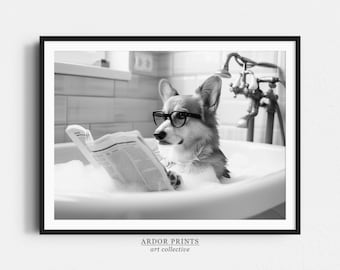 May include: Black and white framed print of a corgi dog wearing glasses and reading a newspaper while relaxing in a bubble bath. The image has a vintage aesthetic and includes the text "ARDOR PRINTS art collective".