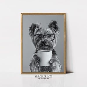 May include: A black and white photograph of a Yorkshire Terrier wearing glasses and holding a white coffee mug. The dog is looking directly at the camera.