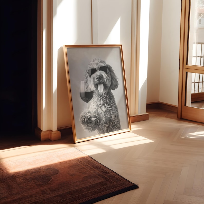 Pu&ograve; includere: Una fotografia in bianco e nero di un cane che indossa occhiali da sole e tiene un bicchiere di vino. La foto &egrave; incorniciata in una cornice dorata e appesa a un muro bianco.