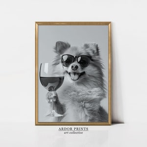 Peut inclure: Une photo en noir et blanc d'un chien portant des lunettes de soleil et tenant un verre de vin rouge. Le chien sourit et regarde la cam&eacute;ra. La photo est encadr&eacute;e dans un cadre dor&eacute;.