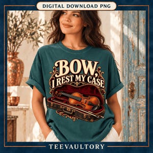 Könnte beinhalten: Ein dunkelblaugrünes Kurzarm-T-Shirt mit einer Grafik einer Geige in einem offenen Koffer. Der Text "BOW, I REST MY CASE" ist in einer dekorativen cremefarbenen Schrift über dem Instrument gedruckt, ergänzt durch florale Verzierungen.