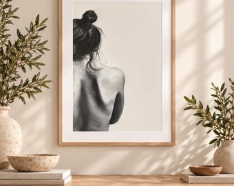 May include: A framed wall art print featuring a black and white charcoal-style drawing of a person seen from the back. The figure has dark hair styled in a bun, with a focus on the contours of the shoulders and back against a light beige background.