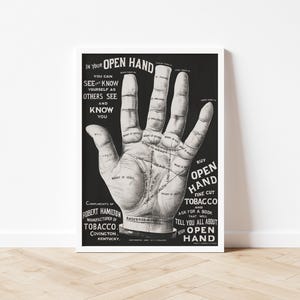 May include: Black and white vintage print featuring a detailed illustration of a palm with lines and text. The print includes text that reads "In Your Open Hand" and "Buy Open Hand Fine Cut Tobacco". The print is framed in a white frame.