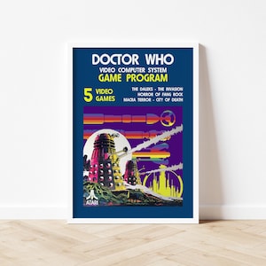 May include: A framed poster for the Doctor Who video game, featuring a retro design. The poster has a dark blue background with the words "Doctor Who" and "Video Computer System Game Program" in white. It lists five video games and features Daleks.