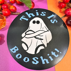 May include: A black and white sticker with a ghost and the text "This is Boo Shit!" in blue lettering.