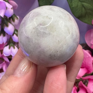 May include: A smooth, white and grey sphere with a subtle sparkle. The sphere is made of natural stone and is a popular choice for crystal healing.
