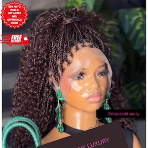 May include: A dark brown lace front wig featuring a high ponytail with micro braids and curly hair texture. The wig includes a sheer lace cap construction at the hairline. The text Kmaussieluxury is visible on a black rectangular label.