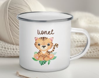 Könnte beinhalten: Weiße Email Tasse mit silbernem Rand und einem niedlichen Tiger-Cartoon mit grünen Blättern. Die Tasse trägt den Namen "Lionel" aufgedruckt.
