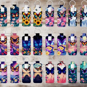 May include: A selection of butterfly-themed keyrings. Each keyring showcases a distinct design with colourful butterflies, flowers, and landscapes. The keyrings are rectangular with a metal ring at the top for attaching keys.