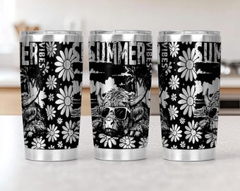 May include: Stainless steel tumbler with a black and white design. The tumbler features a Highland cow wearing sunglasses, palm trees, daisies, and the words "SUMMER VIBES". The design is repeated around the tumbler.