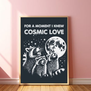 Puede incluir: Ilustración en blanco y negro de tres mapaches mirando hacia arriba a una luna llena con el texto "For a moment I knew COSMIC LOVE" encima de ellos.