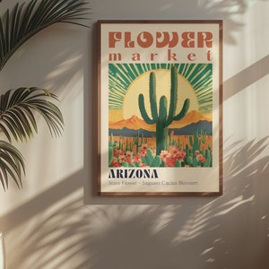 Op de afbeelding: Een vintage poster die reclame maakt voor een bloemenmarkt in Arizona. De poster toont een grote saguaro-cactus in bloei tegen een zonsondergangachtergrond. De tekst luidt "FLOWER market ARIZONA State Flower - Saguaro Cactus Blossom".