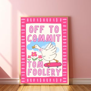 May include: A framed art print with a cartoon illustration of a white goose on a skateboard. The print has a pink border and features the text "OFF TO COMMIT TOM FOOLERY" in pink letters. Pink flowers and blue clouds are also included.
