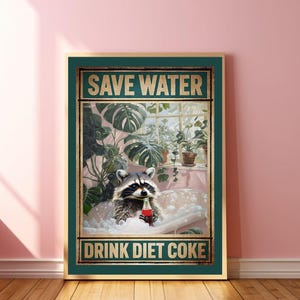 May include: A framed poster with a raccoon in a bathtub, holding a Diet Coke bottle. The poster has the text "SAVE WATER" at the top and "DRINK DIET COKE" at the bottom. The background features a window with plants.