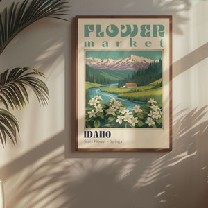 Może przedstawiać: Plakat w stylu vintage reklamujące targ kwiat&oacute;w w Idaho. Plakat przedstawia pasmo g&oacute;rskie, rzekę i małą chatkę. Tekst na plakacie brzmi "Flower Market" i "Idaho, State Flower - Syringa".