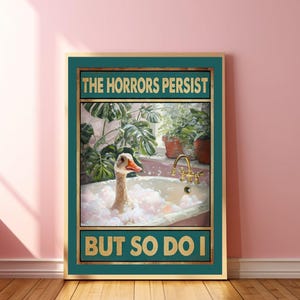 以下が含まれることがあります： 「The Horrors Persist But So Do I」という金色の文字が書かれた緑色のポスター。白いガチョウが泡のあるバスタブに入っています。ガチョウは右を見ています。背景には鉢植えの植物があります。
