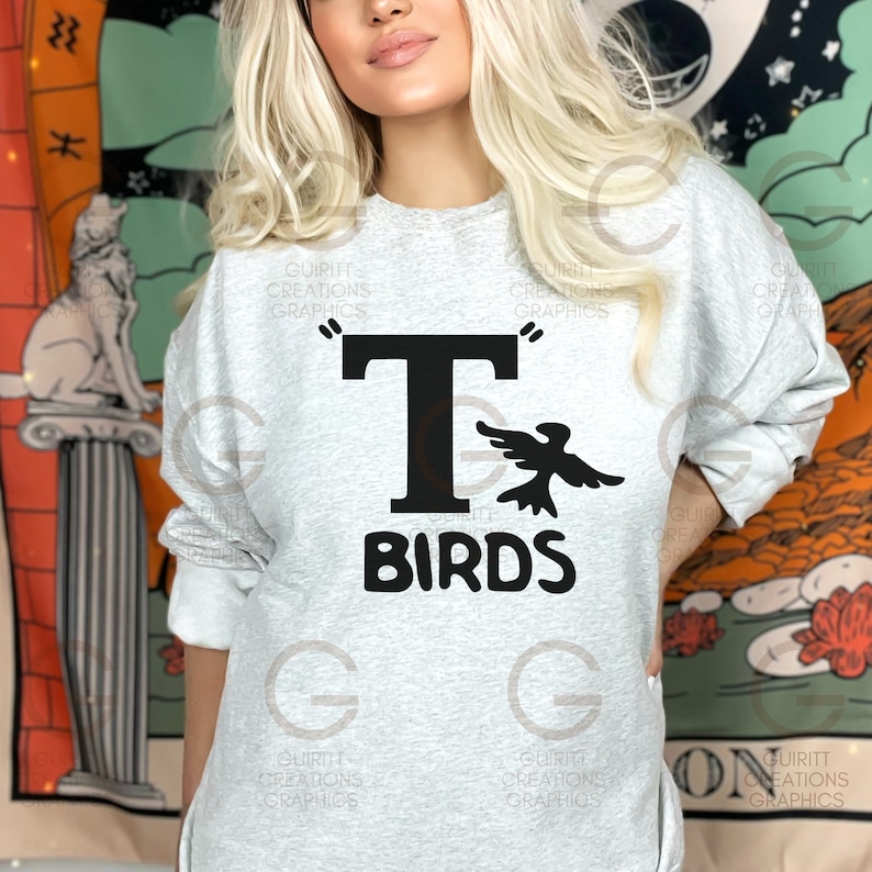 May include: A gray sweatshirt with a black graphic of a bird flying next to a large letter "T" and the word "BIRDS" underneath.