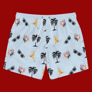 May include: Light blue swim trunks with a repeating pattern of black sunglasses, gold watches, palm trees, and cocktails. The trunks have a white drawstring and are set against a red background.