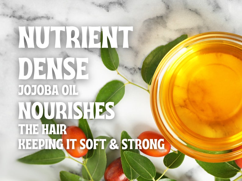 May include: A clear glass bowl filled with golden jojoba oil, surrounded by green leaves and red berries. The text "Nutrient Dense Jojoba Oil Nourishes The Hair Keeping It Soft & Strong" is displayed above the bowl.