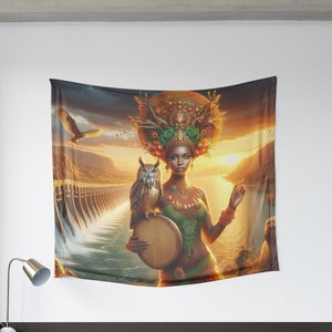 Puede incluir: Un tapiz que presenta a una mujer con un gran tocado adornado con flores y plumas. Ella sostiene un tambor y un búho está posado en su brazo. El fondo es una puesta de sol sobre una masa de agua con una presa en la distancia.