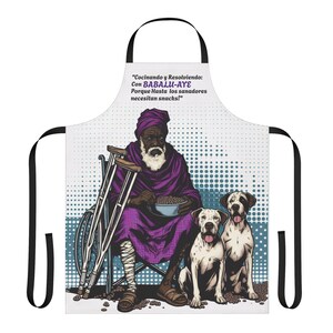 Peut inclure: Un tablier blanc avec une sangle noire et une illustration colorée d'un homme assis sur une chaise avec deux chiens. L'homme porte une robe violette et un turban. Le texte sur le tablier est "Cocinando y Resolviendo: Con BABALU-AYE Porque Hasta los sanadores necesitan snacks!"