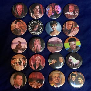 May include: A collection of twenty round pinback buttons featuring images of characters and scenes from the television show Twin Peaks. The buttons display various portraits and quotes, including "Damn Fine Cup of Coffee."
