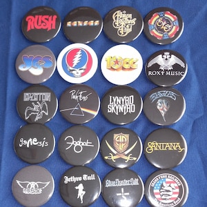 May include: A collection of 18 round black and white button pins featuring logos of various rock bands, including Rush, Kansas, The Allman Brothers Band, Yes, The Grateful Dead, 10cc, Roxy Music, Led Zeppelin, Pink Floyd, Lynyrd Skynyrd, Genesis,  Foghat, Jethro Tull, Blue Oyster Cult, and Grand Funk Railroad.