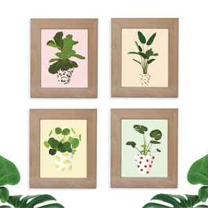 Puede incluir: Cuatro impresiones enmarcadas de plantas en maceta con macetas estampadas. Las impresiones están en marcos de madera con un acabado marrón claro. Las plantas son una higuera de hoja de violín, una monstera, una lirio de la paz y una cadena de perlas. Las macetas están estampadas con cerezas, limones, fresas y lunares.